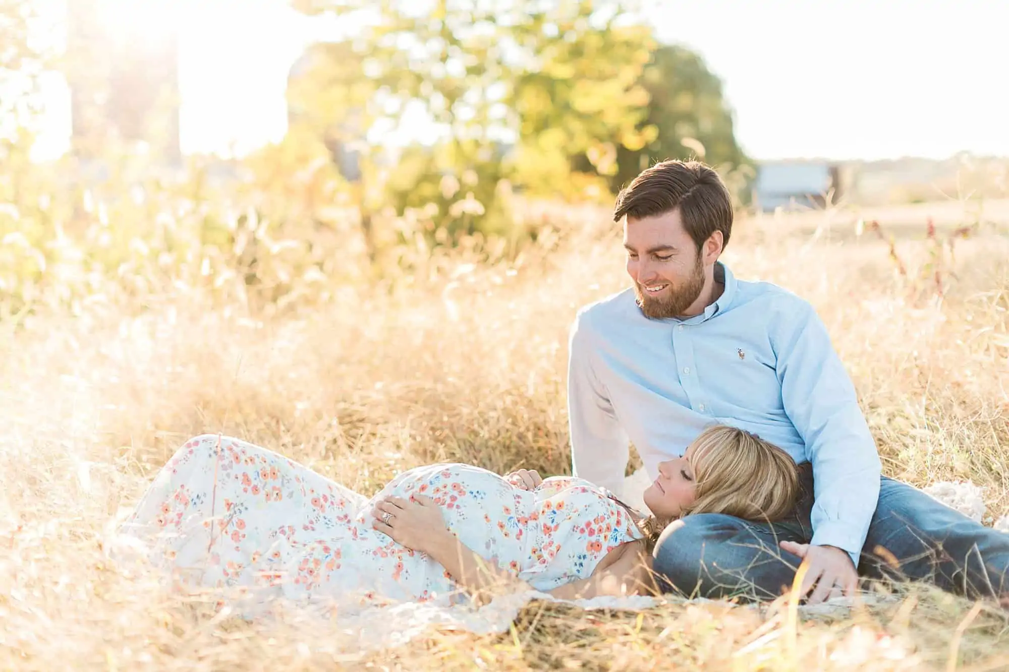 Couple laying down in field for outdoor Charlottesville VA maternity photography session