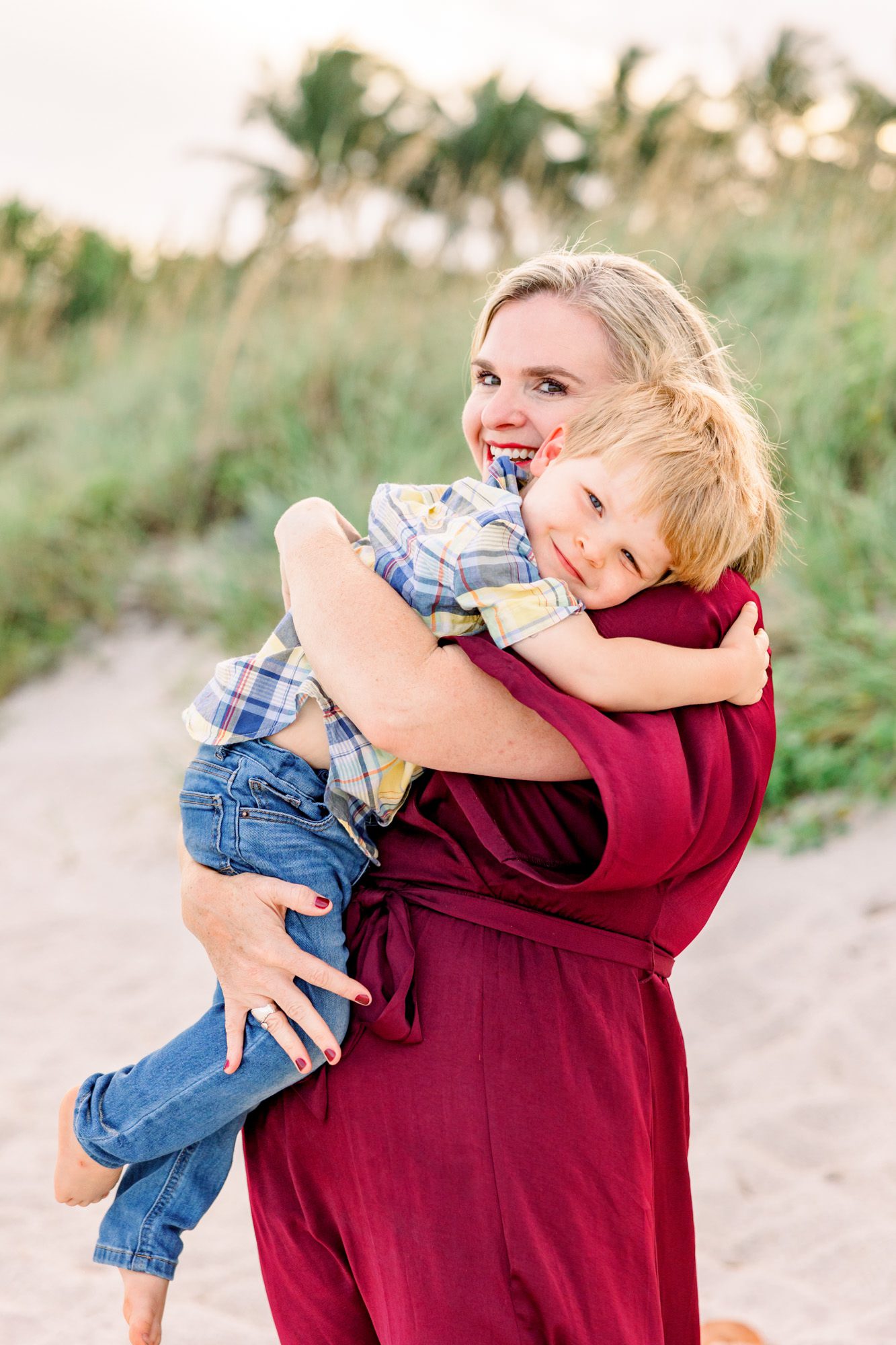 Mom in red dress hugging young son