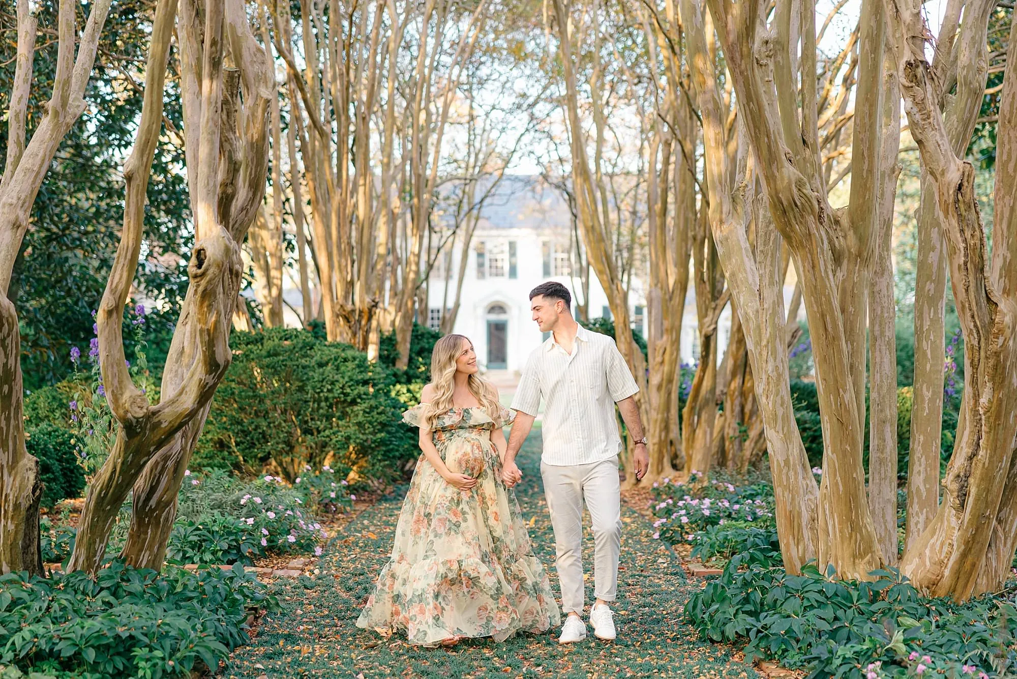 Couple walking through crape myrtle trees for RVA maternity session