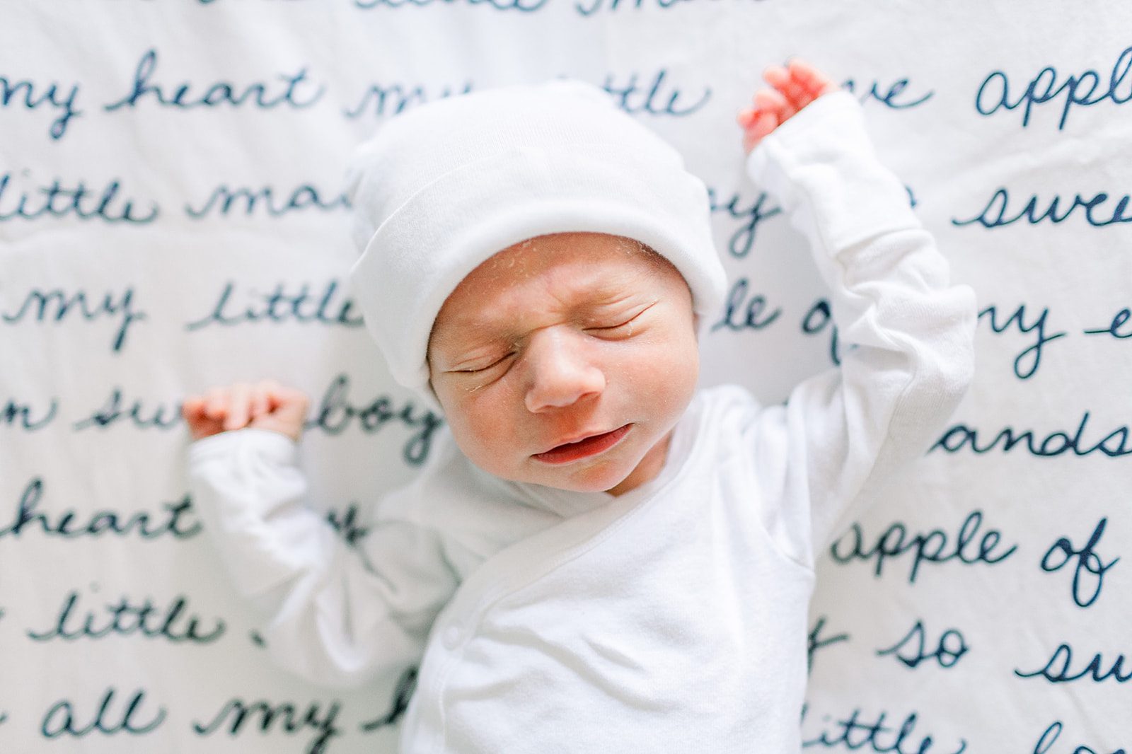 The Top 5 Charlottesville Doulas for a Positive Birth Experience 1 Sleeping newborn in a crib, dressed in a white hat and white onesie, peacefully resting on a soft blanket.