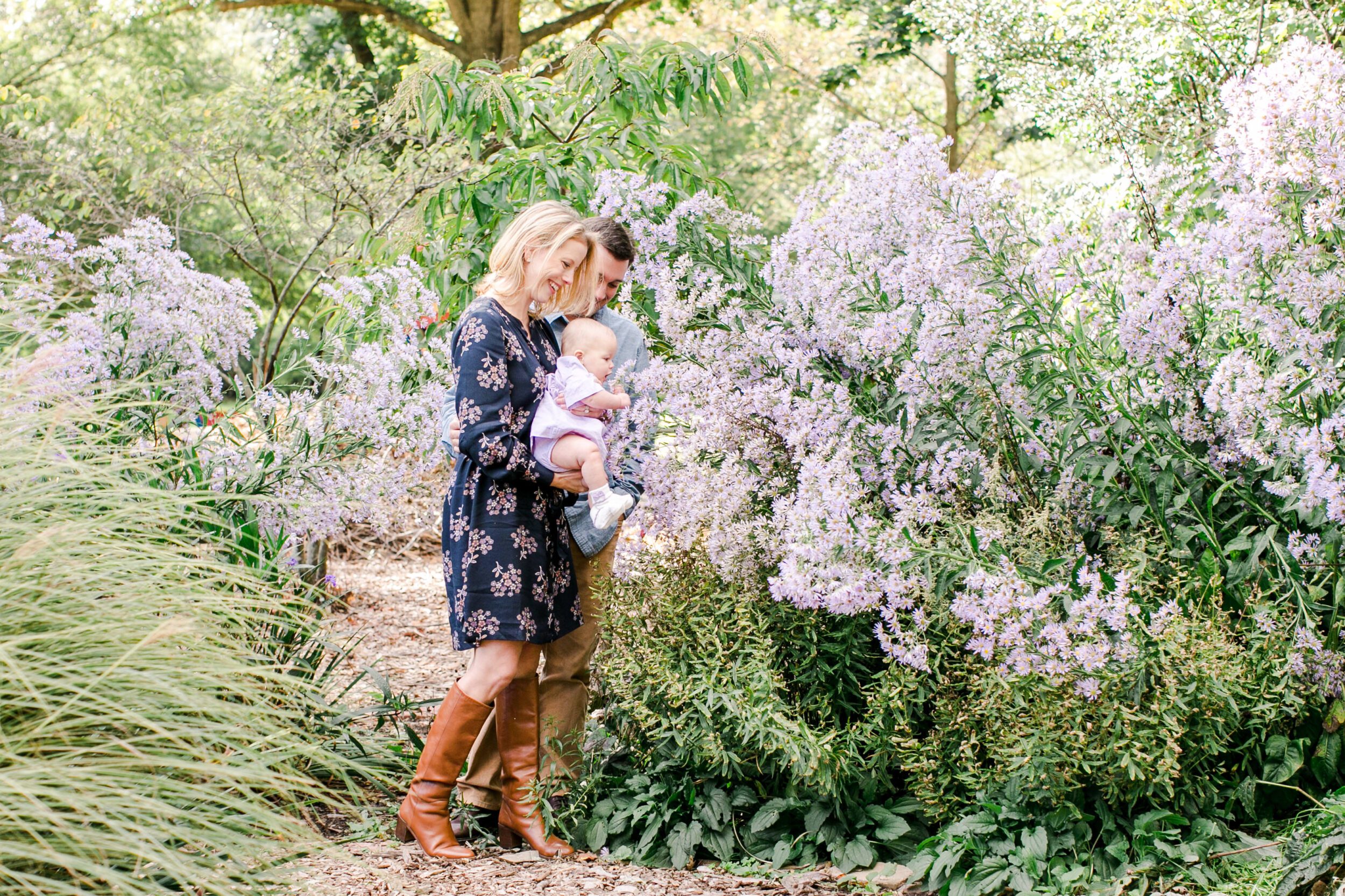 Spring Family Photo Outfits: A Complete Style Guide 1 Family of four in navy blue and floral spring family photoshoot outfits standing in a green park setting