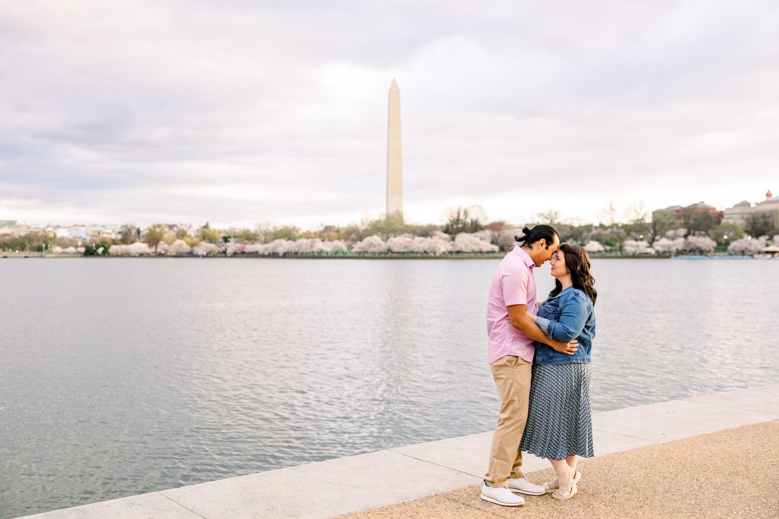 Spring Family Photo Outfits: A Complete Style Guide 4 Couple posing in front of the Washington Monument and Cherry Blossom trees at the Tidal Basin in DC